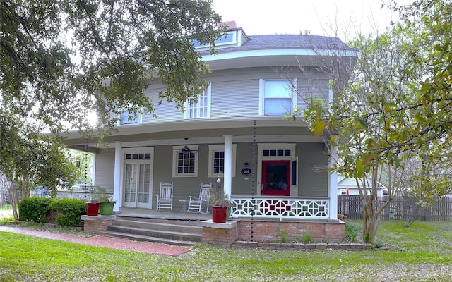 view of front of house with a front lawn, ceiling fan, and a porch