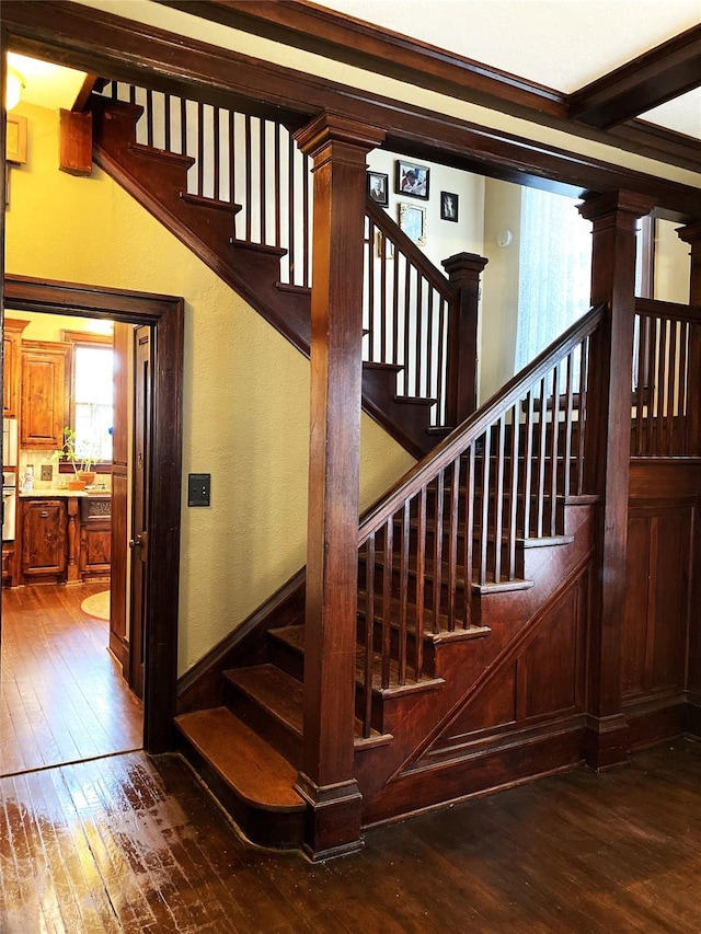 staircase featuring ornate columns and hardwood / wood-style flooring