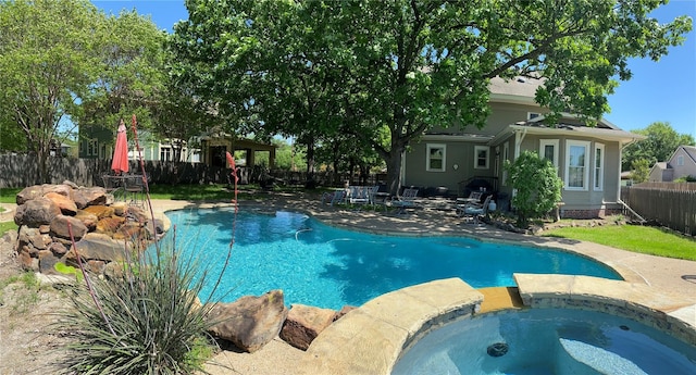 view of pool featuring a patio area and an in ground hot tub