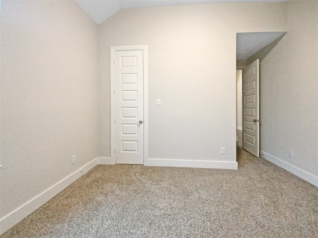 unfurnished room with vaulted ceiling and light colored carpet