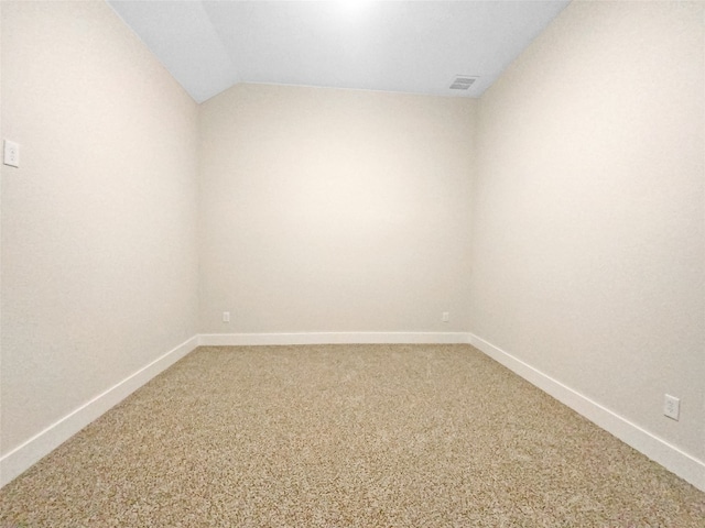 carpeted empty room with vaulted ceiling