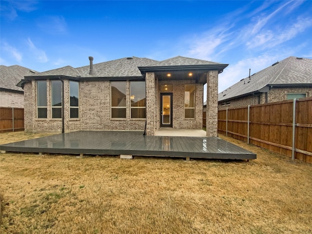 back of house featuring a wooden deck and a yard