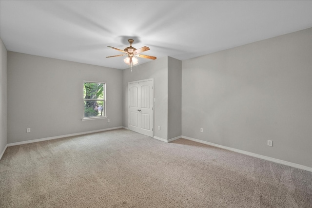 carpeted spare room featuring ceiling fan