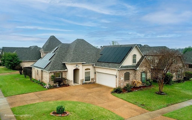 view of front of property with a front yard, a garage, and solar panels