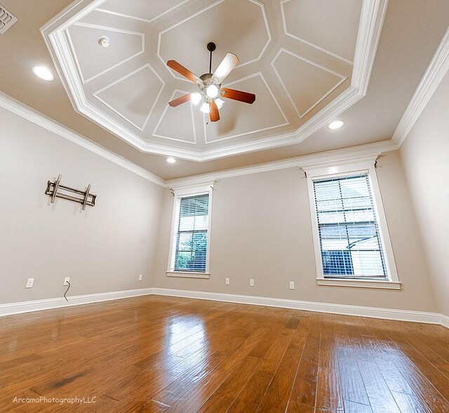 spare room with coffered ceiling, ornamental molding, ceiling fan, and wood-type flooring