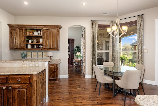 dining space with dark hardwood / wood-style flooring and a chandelier