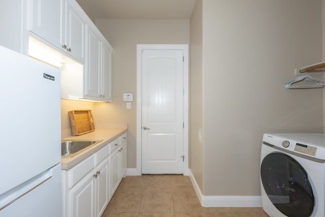 laundry room featuring cabinets, light tile patterned floors, washer / clothes dryer, and sink