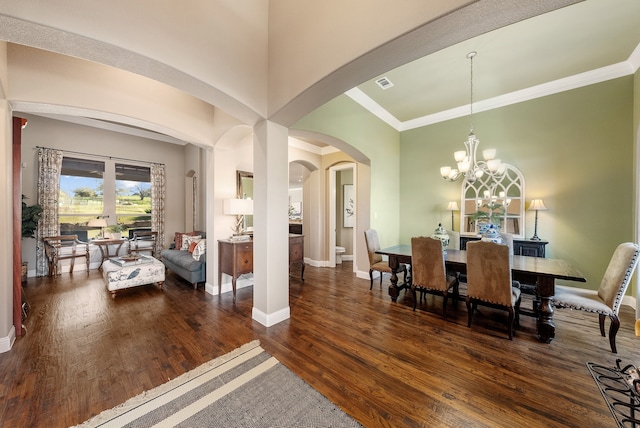 dining room featuring dark wood-type flooring, crown molding, and a notable chandelier