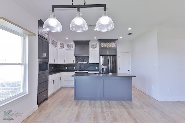 kitchen featuring white cabinets, hanging light fixtures, backsplash, and stainless steel refrigerator with ice dispenser