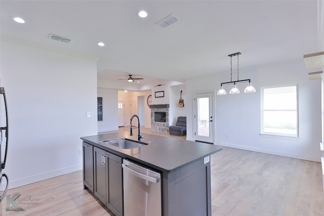 kitchen featuring ceiling fan, a fireplace, sink, light wood-type flooring, and dishwasher