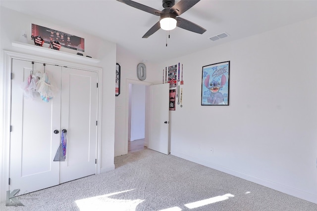 unfurnished bedroom featuring a closet, ceiling fan, and light colored carpet