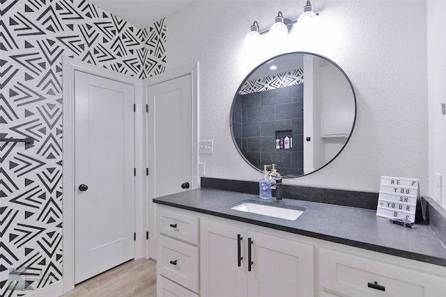 bathroom with large vanity and hardwood / wood-style flooring