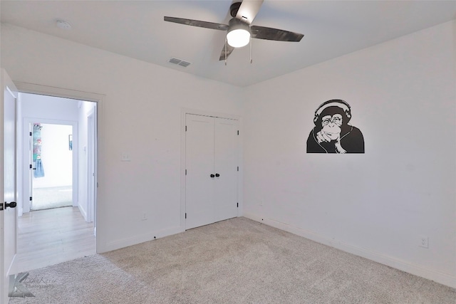 empty room with ceiling fan and light hardwood / wood-style flooring