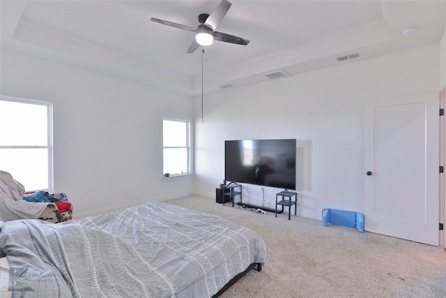 bedroom with ceiling fan, a raised ceiling, and light colored carpet