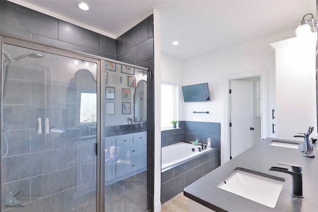 bathroom with dual vanity, independent shower and bath, and wood-type flooring