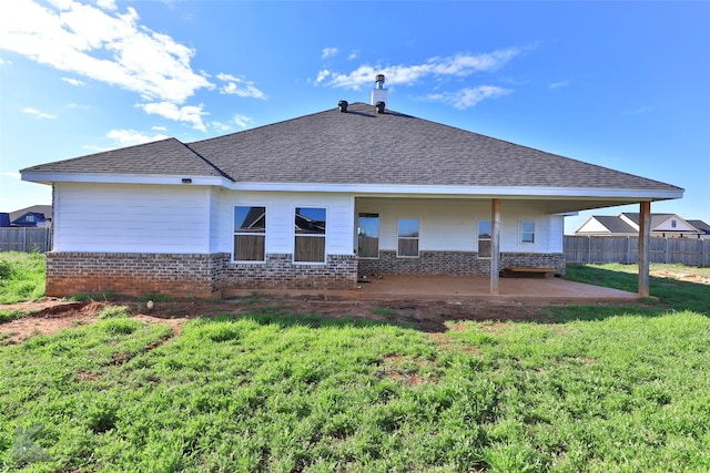 rear view of house with a yard and a patio