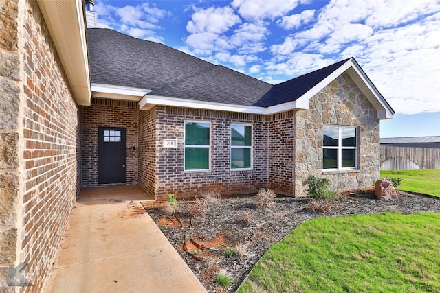 property entrance with a lawn