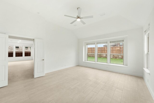 empty room featuring ceiling fan, vaulted ceiling, and light hardwood / wood-style flooring