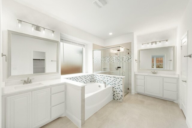 bathroom featuring shower with separate bathtub, vanity with extensive cabinet space, and tile flooring