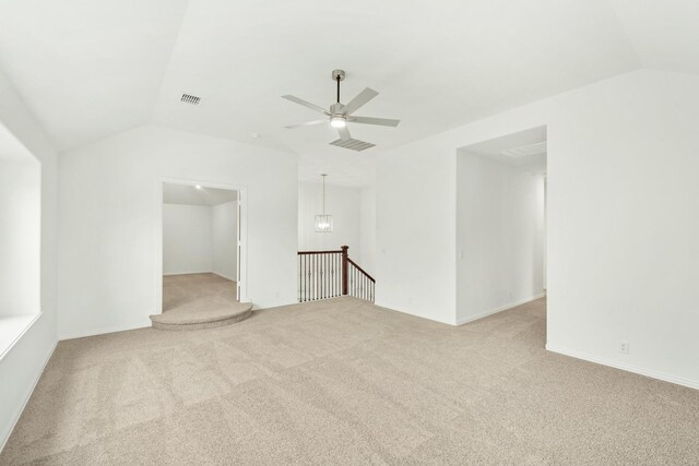 spare room featuring carpet floors, ceiling fan, and vaulted ceiling