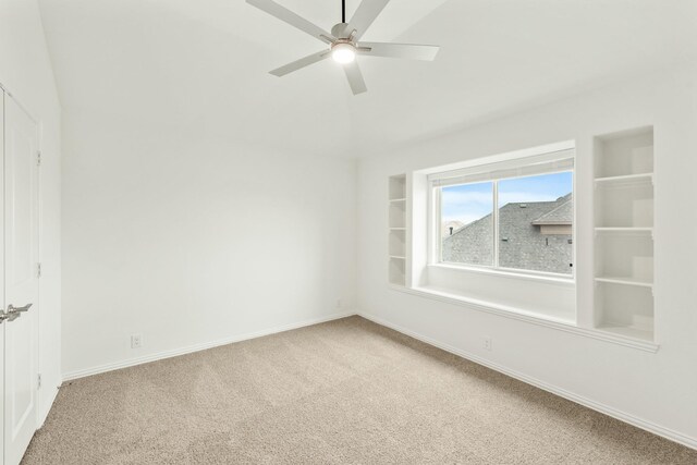 empty room featuring carpet flooring, ceiling fan, and vaulted ceiling