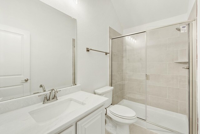 bathroom with a shower with door, tile floors, lofted ceiling, toilet, and vanity