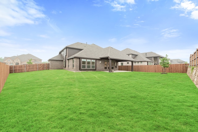 back of house featuring a lawn and a patio area