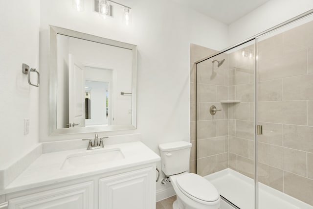 bathroom with a shower with shower door, vanity, and toilet