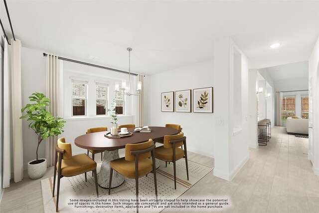 dining room with light hardwood / wood-style flooring and an inviting chandelier