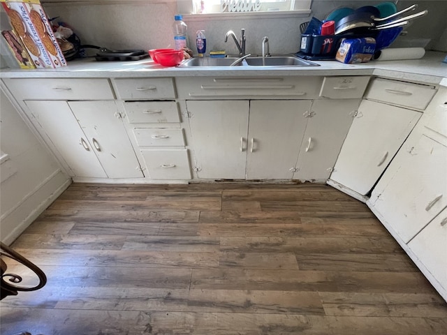 kitchen with white cabinets, dark wood-type flooring, and sink