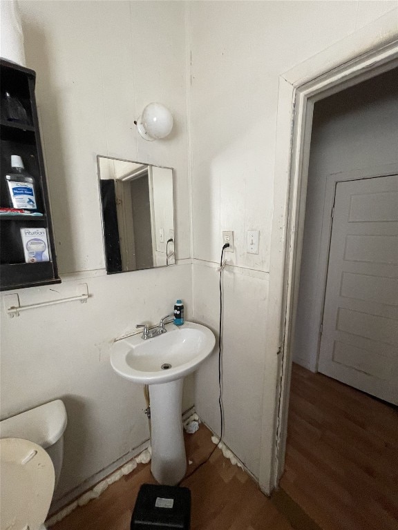 bathroom with toilet and wood-type flooring