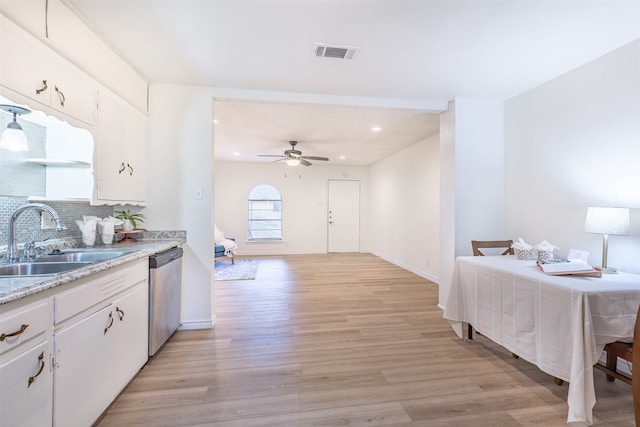 kitchen with stainless steel dishwasher, tasteful backsplash, white cabinets, sink, and light hardwood / wood-style floors