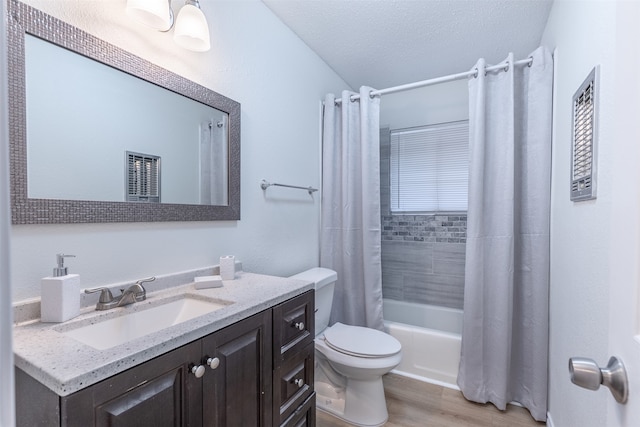 full bathroom with vanity, wood-type flooring, shower / bathtub combination with curtain, toilet, and a textured ceiling