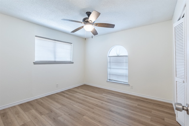 unfurnished bedroom featuring light wood-type flooring, ceiling fan, and a closet