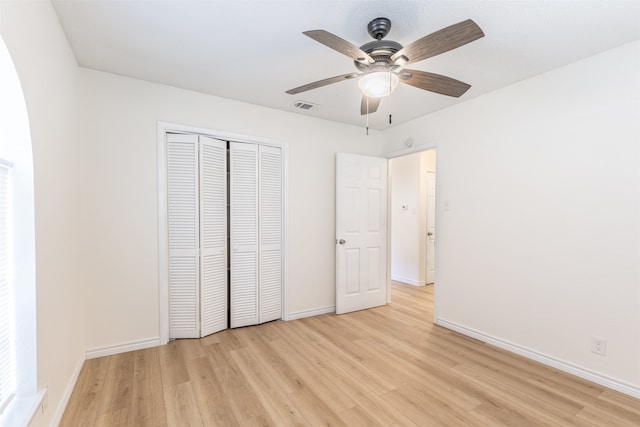 unfurnished bedroom with ceiling fan, light hardwood / wood-style flooring, and a closet