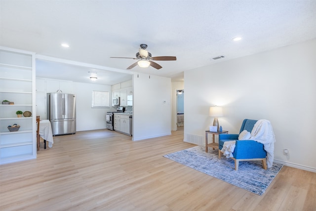 sitting room featuring ceiling fan and light wood-type flooring