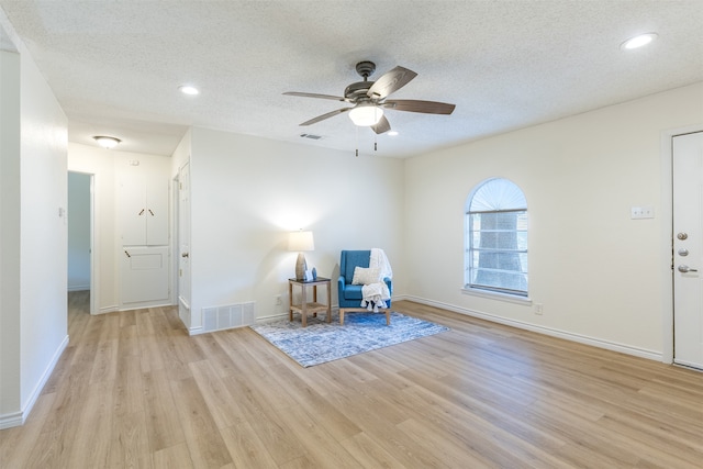 unfurnished room featuring ceiling fan, a textured ceiling, and light hardwood / wood-style floors