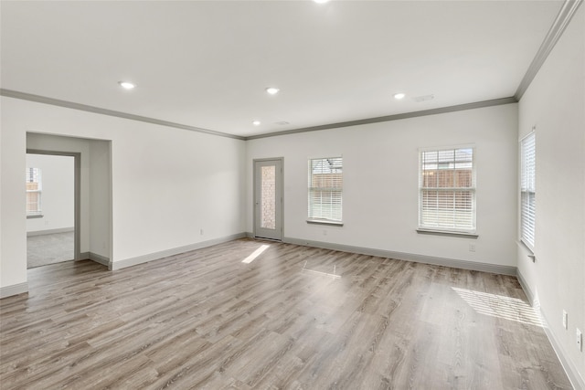 spare room featuring ornamental molding and light hardwood / wood-style flooring