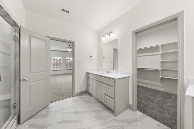 bathroom featuring ceiling fan, vanity, and walk in shower