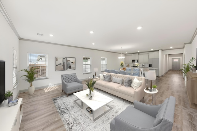 living room with light wood-type flooring and crown molding