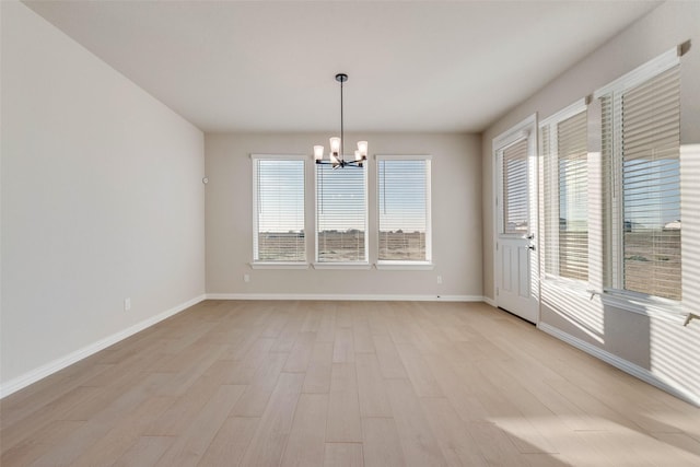 empty room featuring light hardwood / wood-style floors and an inviting chandelier