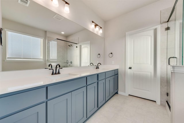 bathroom featuring tile patterned floors, vanity, and a shower with shower door