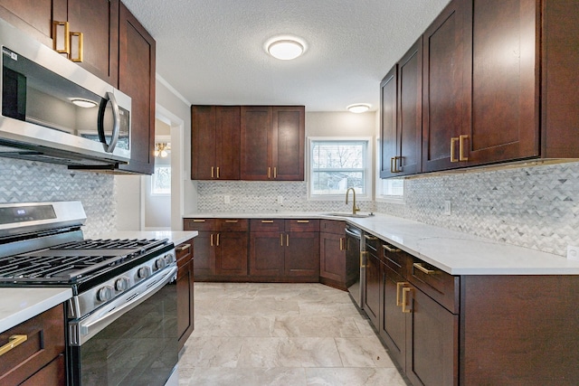 kitchen with backsplash, appliances with stainless steel finishes, sink, light tile floors, and a textured ceiling