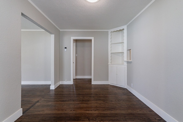 spare room featuring built in features, dark hardwood / wood-style floors, and a textured ceiling