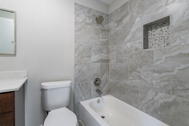 full bathroom with toilet, vanity, and tiled shower / bath