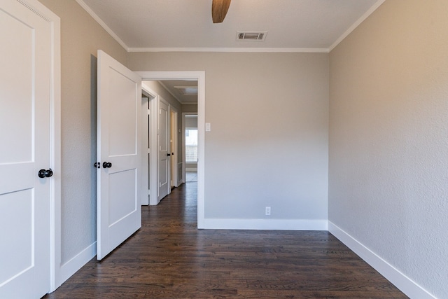 empty room featuring dark hardwood / wood-style flooring, ceiling fan, and crown molding