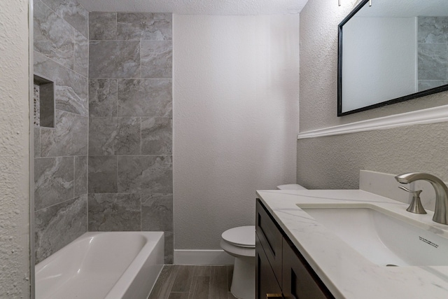 bathroom with a textured ceiling, toilet, oversized vanity, and wood-type flooring