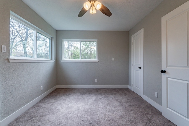 carpeted spare room featuring ceiling fan