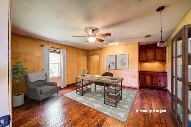 office with visible vents, baseboards, dark wood finished floors, track lighting, and a ceiling fan