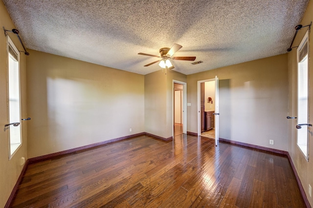 empty room featuring a ceiling fan, dark wood-style floors, and baseboards